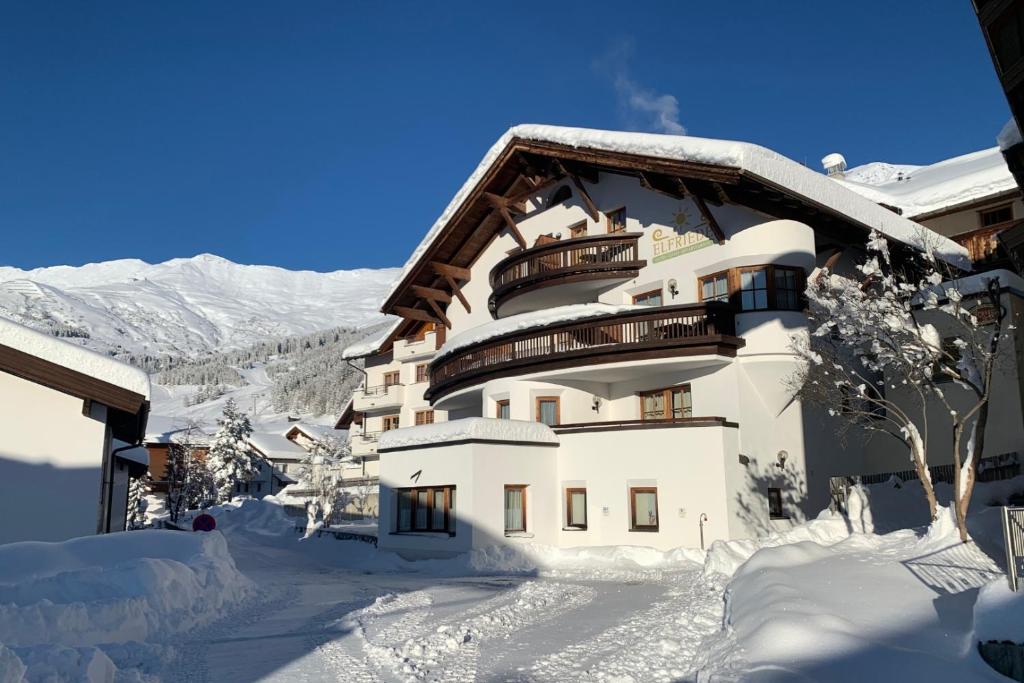 费斯Chalet Elfriede的一座带雪盖的建筑,上面设有一个阳台