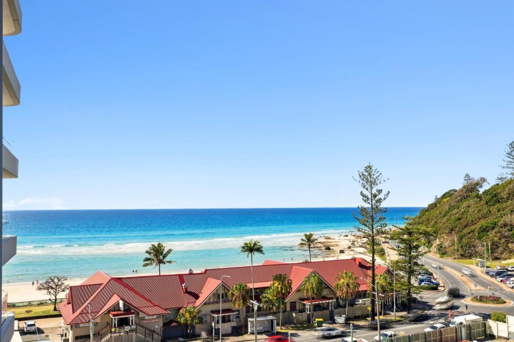 a view of the beach from the balcony of a resort at Beachfront 1-Bed Flat with Pool & Gym Access in Gold Coast