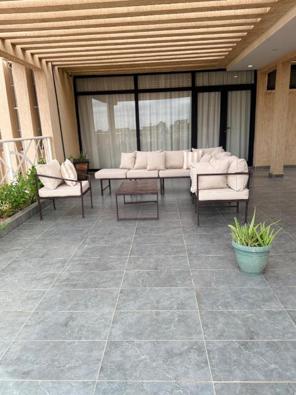 a patio with couches and tables in a building at Kalinou Niamey in Niamey