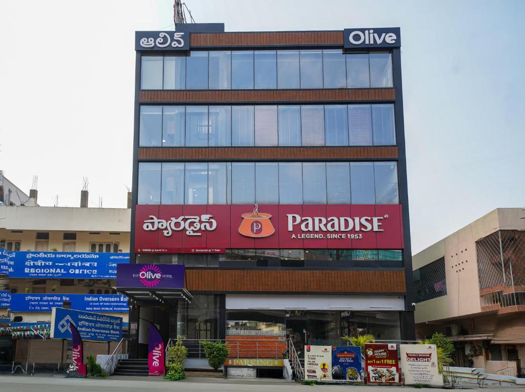 un gran edificio con un cartel para una tienda de panisse en Olive Hotel Benz Circle, Vijayawada by Embassy Group, en Vijayawāda