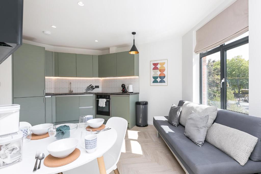 a kitchen and living room with a table and a couch at Luxe 2 bed - 20 minutes from Central London in London