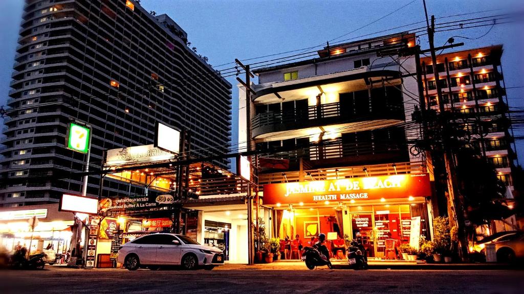 a city street with buildings and a white car parked in front at VS Beach Front in Jomtien Beach
