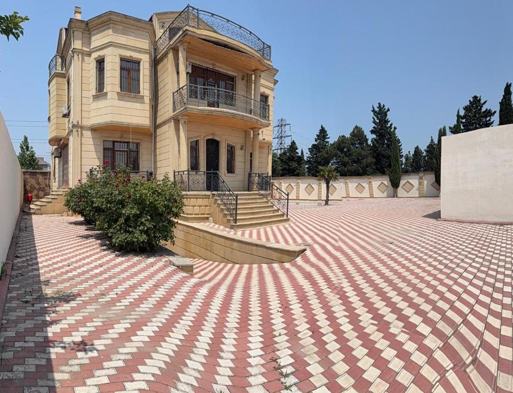 an old house with a brick courtyard in front of it at Super Villa in Mardakan