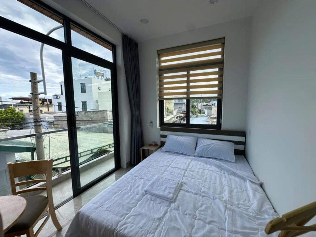 a bedroom with a bed and a large window at Homstay Thái Sơn in Ninh Hải