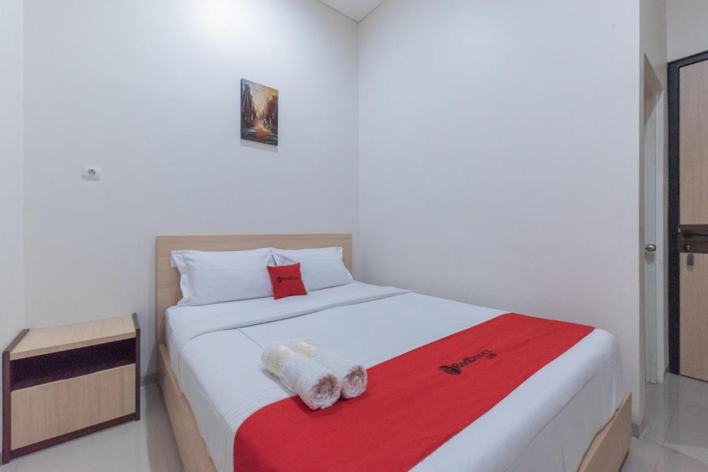 a bedroom with a bed with two stuffed animals on it at RedDoorz near CSB Mall Cirebon in Cirebon