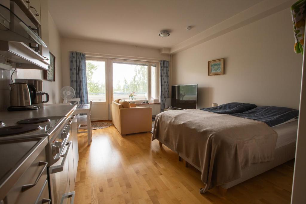 a small bedroom with a bed and a kitchen at Lil Haven Cozy Studio with Sauna, Glassed Balcony and Free Parking in Kemi