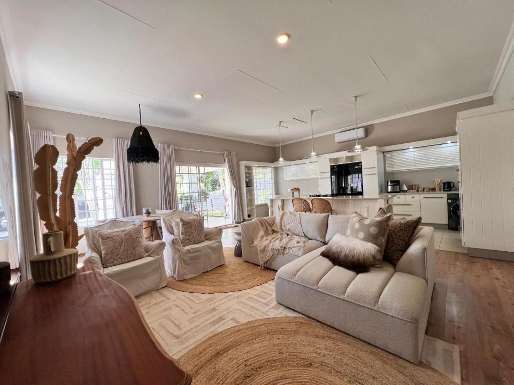 sala de estar con 2 sofás blancos y cocina en Whispering Thorns Off-Site Apartment, en White River