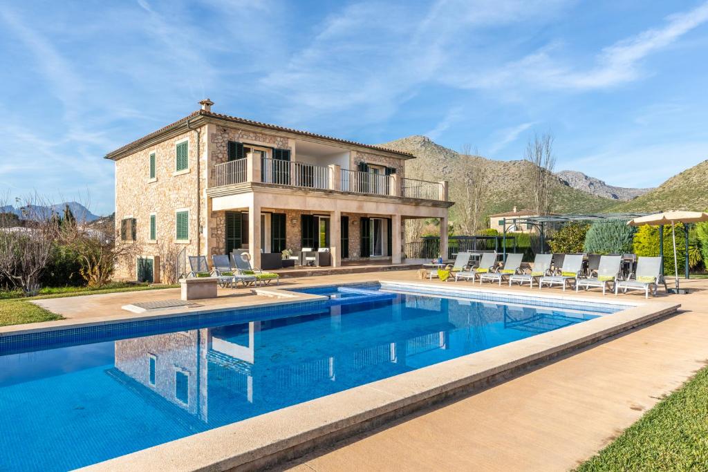 a house with a swimming pool in front of a house at Spacious villa for 10 with private pool in El Port