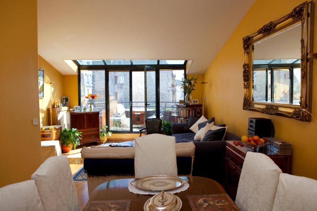 sala de estar con sofá y espejo en 52 Clichy Bed & Breakfast - Chambre d'hôtes en París