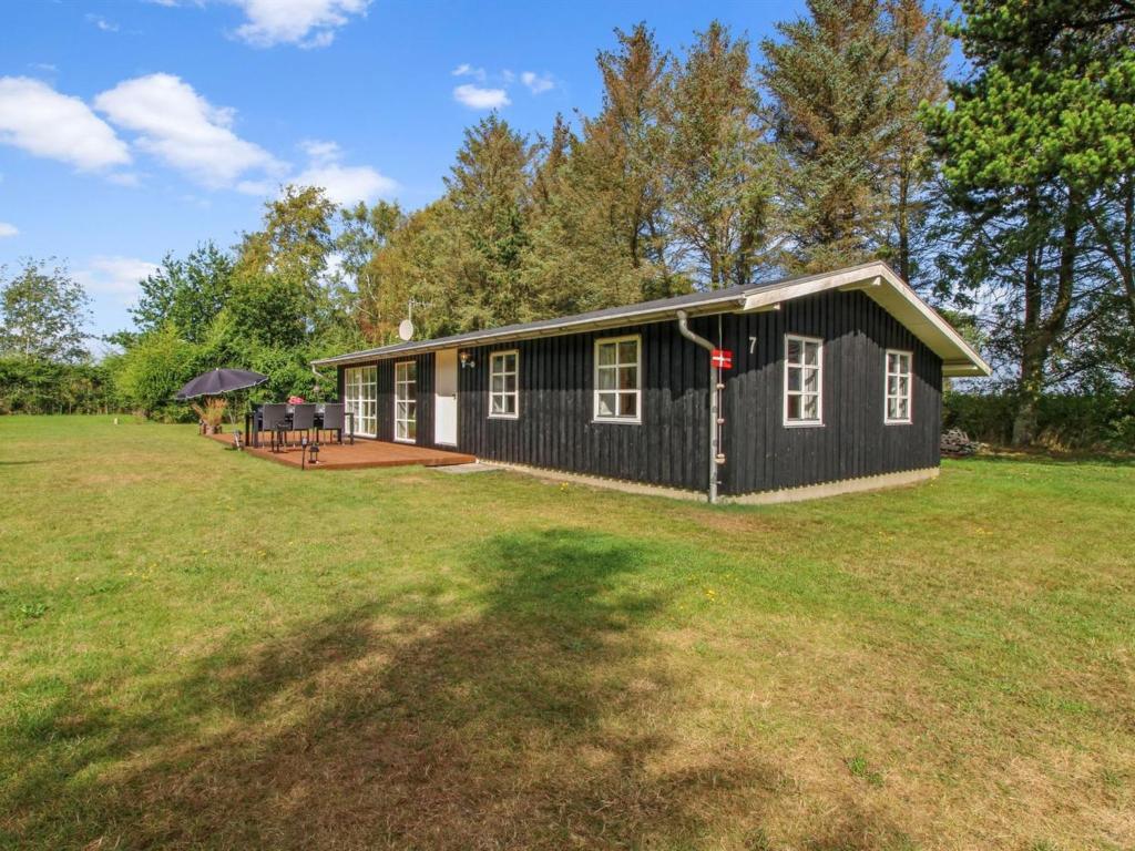 a black and white house on a grass field at Holiday Home Salgarth - 450m from the sea by Interhome in Sæby