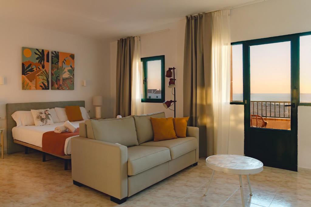 un soggiorno con un divano e un letto di Apartamentos Moon Dreams Cabo de Baños a Cala en Blanes