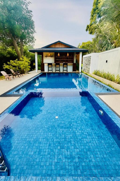 a swimming pool in front of a house at Hotel sunflower in Dambulla