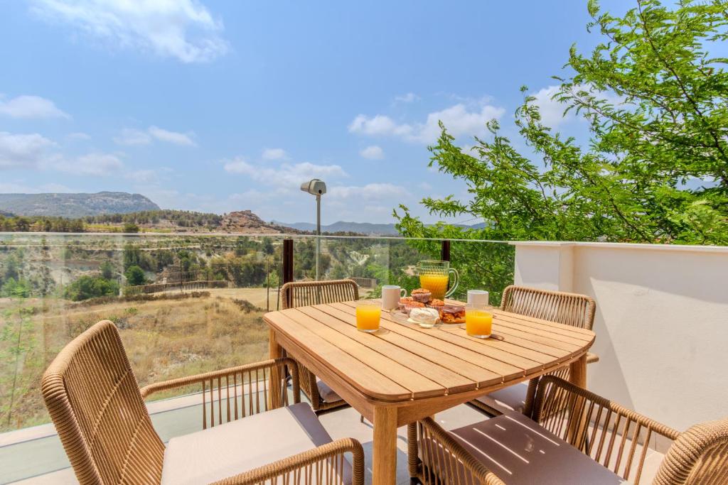 a wooden table and chairs on a balcony with a view at La Casa de la tía Libre - Entorno rural y descanso in Tibi