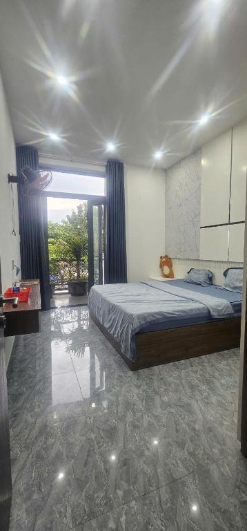a bedroom with a bed and a large window at COMIC Homestay in Danang