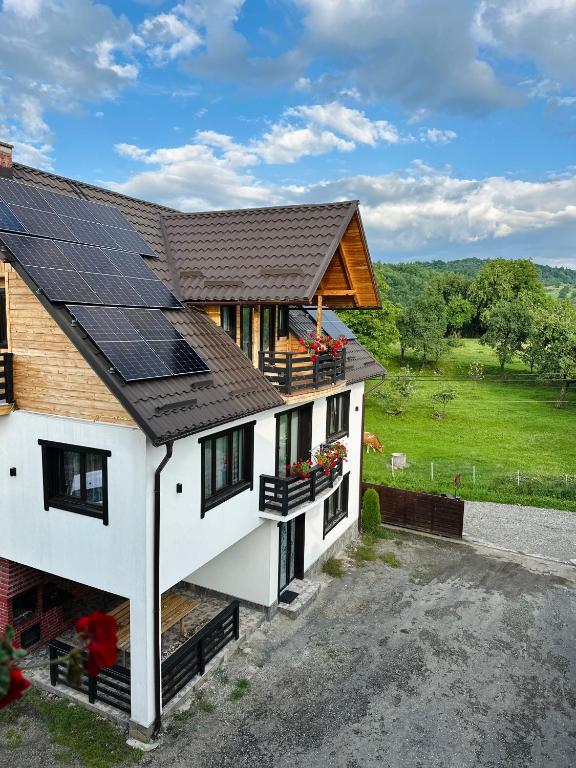 a house with solar panels on the roof at Pensiunea Casa Petran in Breb