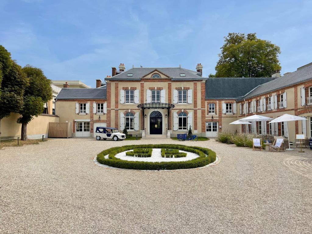 a large house with a fountain in front of it at Les Suites BB, Champagne Besserat de Bellefon in Épernay