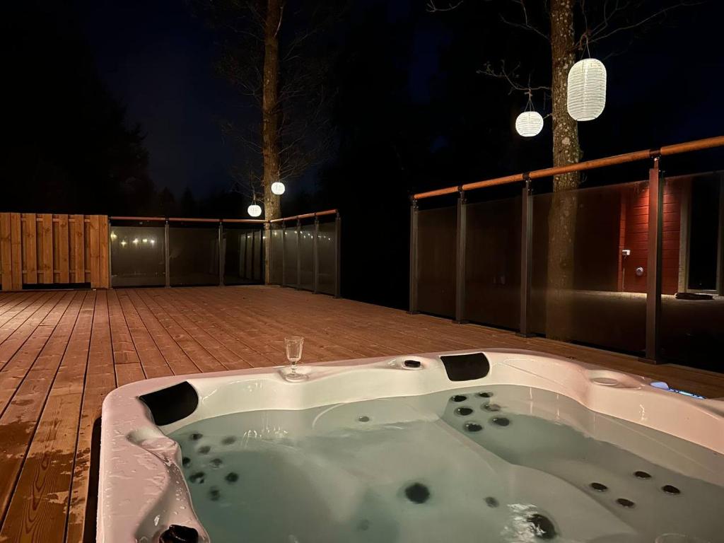 a jacuzzi tub sitting on a deck at night at Log cabin with hot tub and views in Ludvigsborg