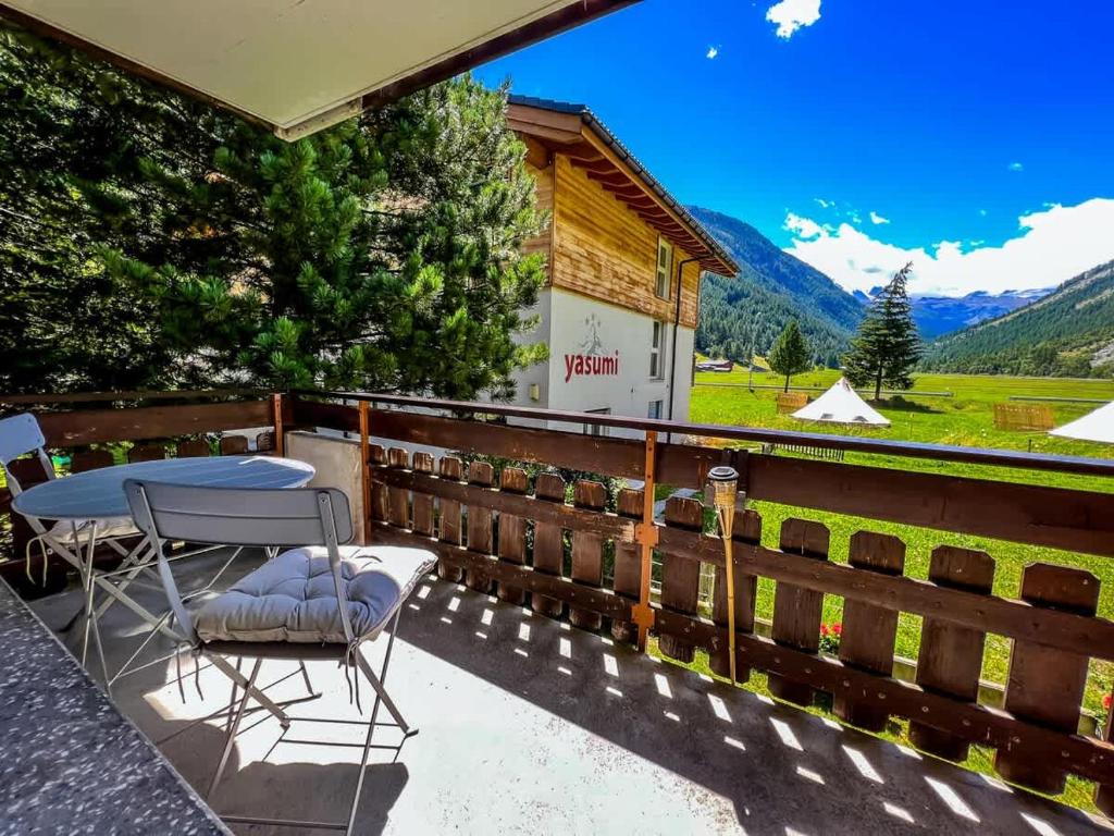 a patio with a table and chairs and a building at Panorama hideaway apartment near Zermatt with parking! in Täsch