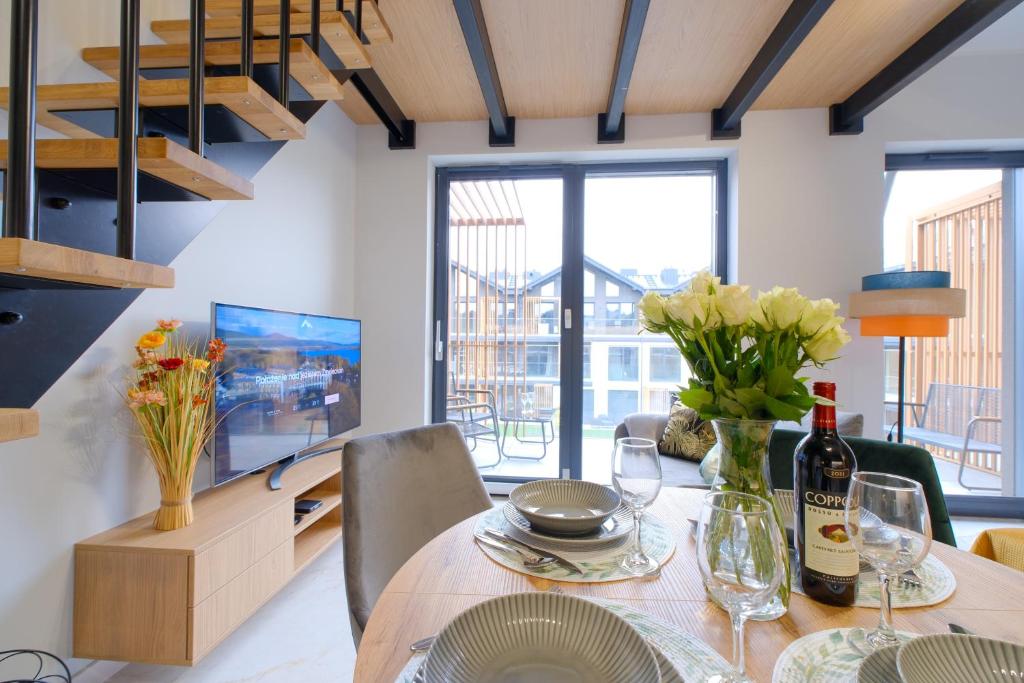 une salle à manger avec une table fleurie et une télévision dans l'établissement Laguna Beskidów Resort - Piwniczka Pascala, à Zarzecze