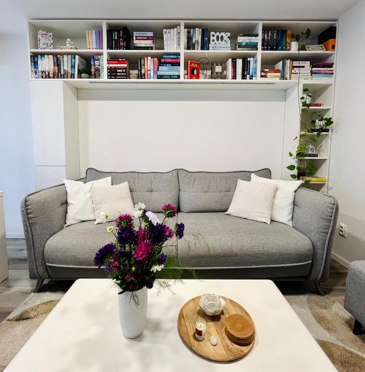 a living room with a couch and a table with flowers at Downtown Apartment in Trnava