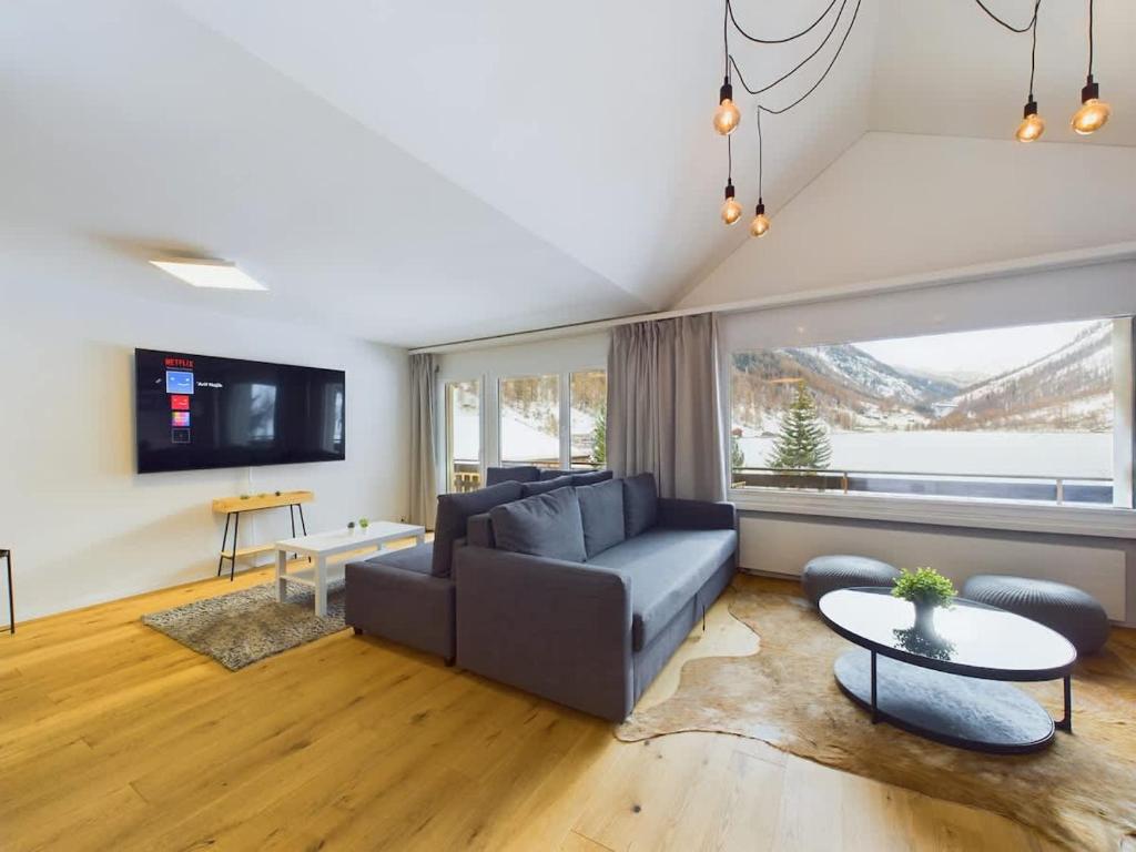 a living room with a couch and a table at Mountain Majesty Apartment with Stunning Views in Täsch