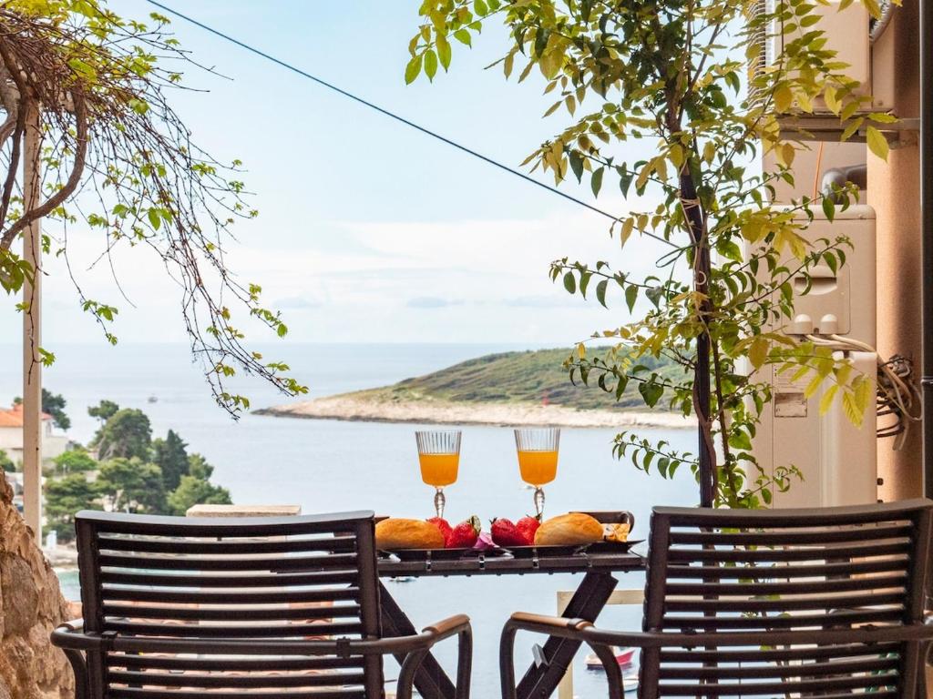 two chairs and a table with two glasses of orange juice at Apartman Jakša in Hvar