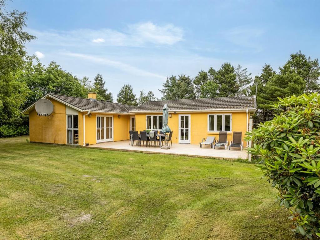 a yellow house with a yard at Holiday Home Ahnandia - 200m from the sea by Interhome in Jerup