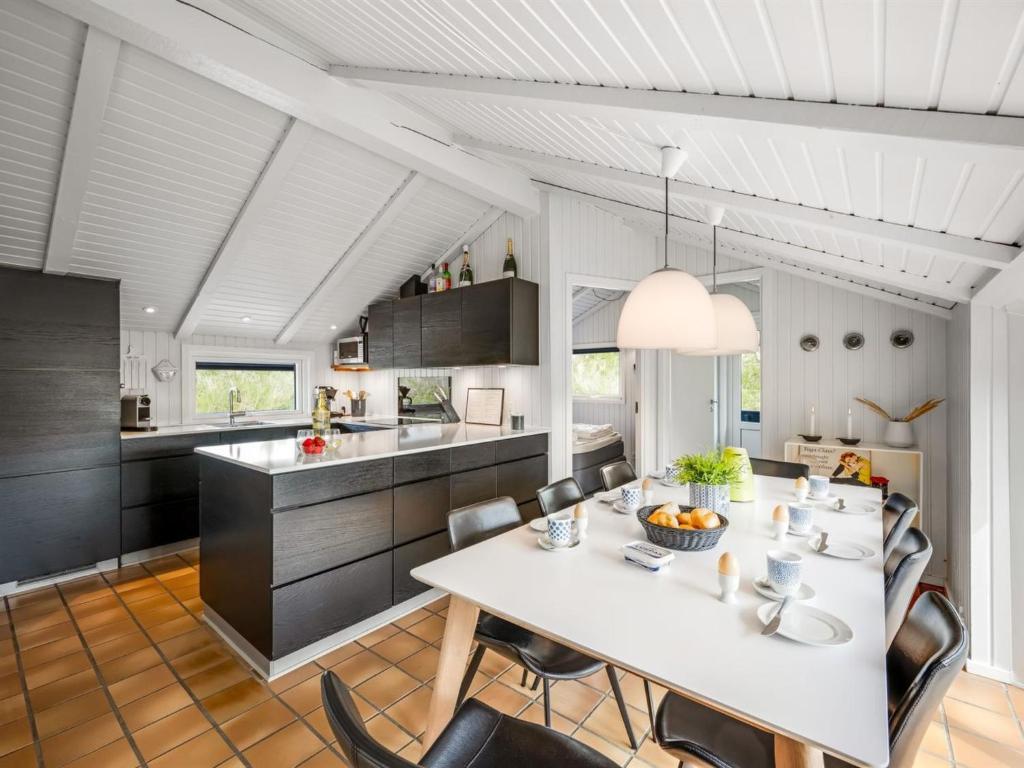 a kitchen and dining room with a white table and chairs at Holiday Home Emin - 700m from the sea by Interhome in Vejers Strand