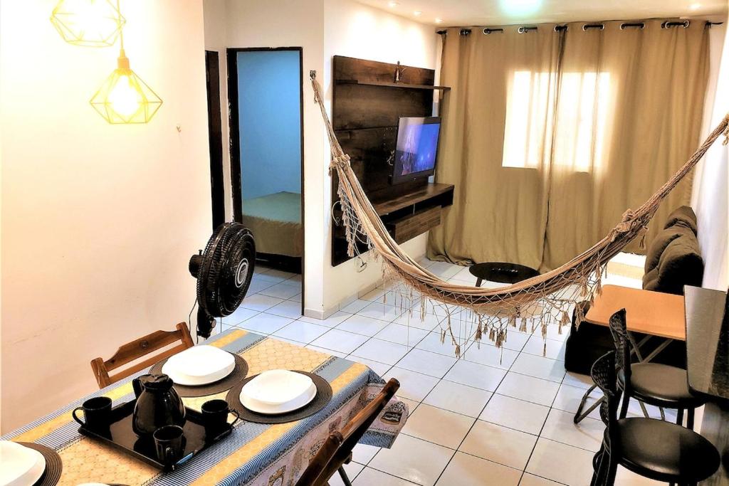 a living room with a hammock and a table and chairs at Dona Lindu 3 - Bodocongo (Campina Grande-PB) in Campina Grande
