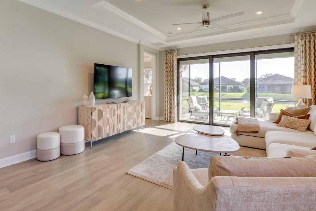 Chic Getaway in Bradenton with Pool Access في Lorraine: غرفة معيشة مع أريكة وتلفزيون