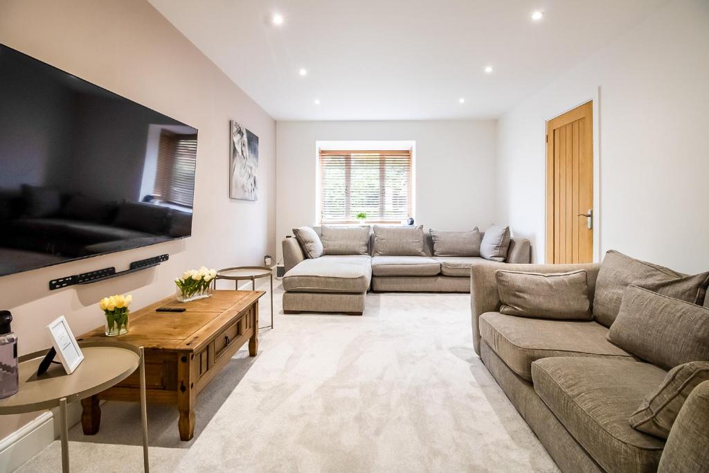 a living room with a couch and a table at Beautiful and Cosy 4-bed Home in Milton Keynes by Renzo, Driveway, Close to M1 in Milton Keynes