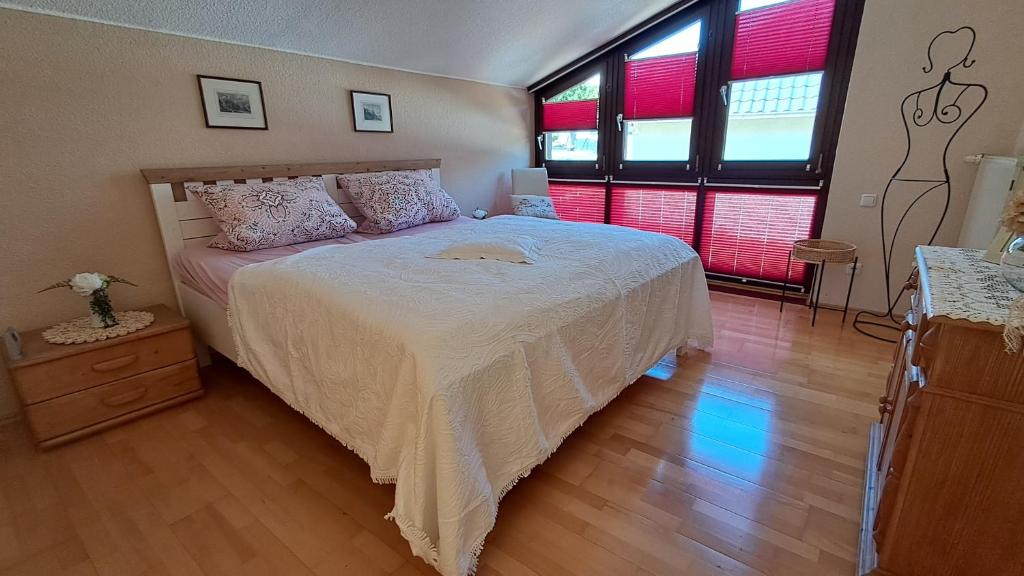 a bedroom with a bed and two windows at ChristRose in Trechtingshausen