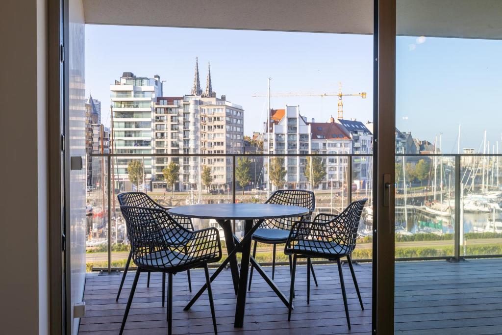einen Tisch und Stühle auf einem Balkon mit Stadtblick in der Unterkunft Sky Harbour - GAR 58 in Ostende