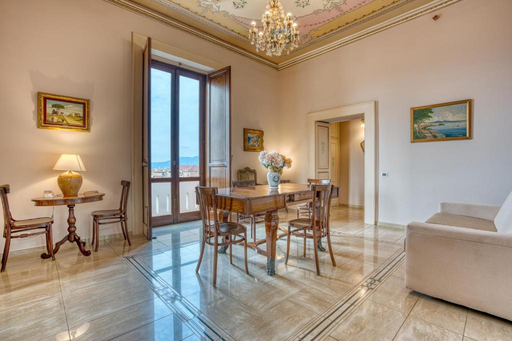 Una sala de estar con una mesa y sillas y un sofá. en La Baronessa Apartment near Pompei & Amalfi Coast, en Angri
