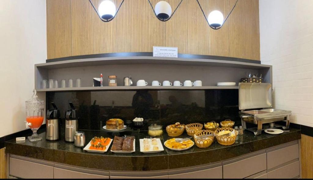 a buffet of food on a counter in a restaurant at Hotel Pinheiro in Unaí