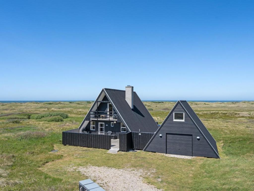 a black house in the middle of a field at Holiday Home Viona - 350m from the sea by Interhome in Pandrup