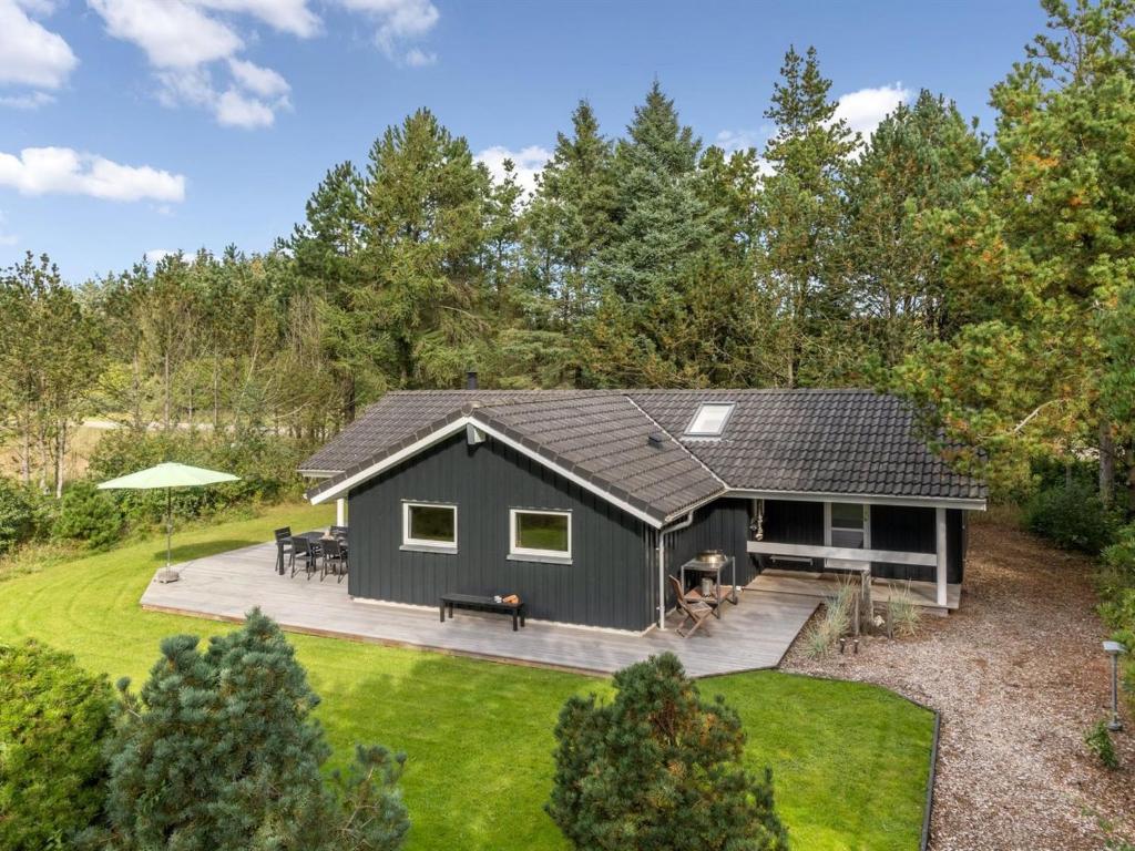 a gray house with a deck in the yard at Holiday Home Grimi - 4km from the sea by Interhome in Fjerritslev