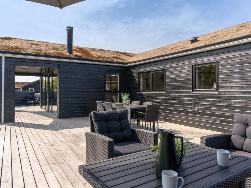 Un patio con sillas y una mesa en una casa. en Holiday Home Dyke - 1-5km from the sea by Interhome, en Saltum