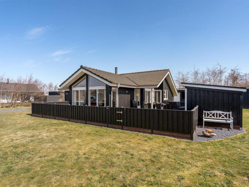 a house with a fence in a yard at Holiday Home Dorithea - 3-5km from the sea by Interhome in Brovst