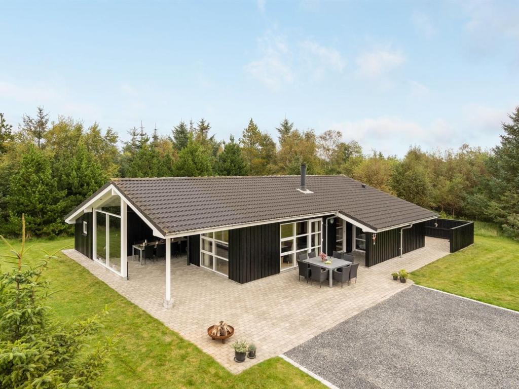 a house with a black roof and a patio at Holiday Home Frida - 700m from the sea by Interhome in Fjerritslev