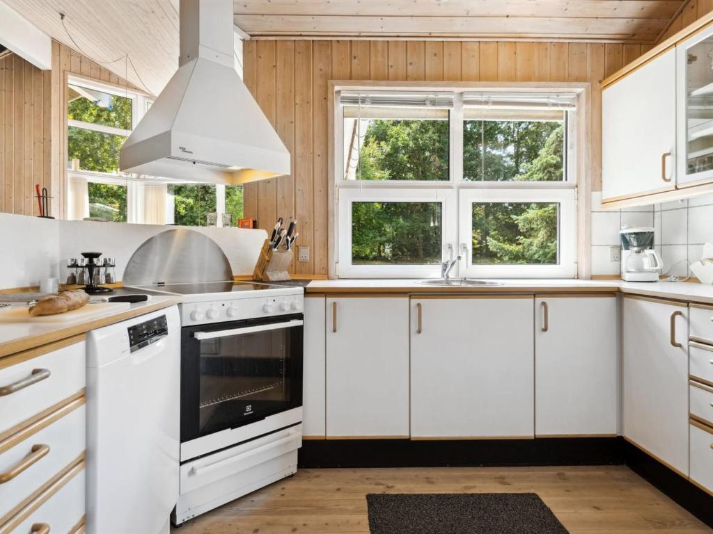 a kitchen with white cabinets and windows at Holiday Home Karitte - 5km from the sea by Interhome in Fjerritslev