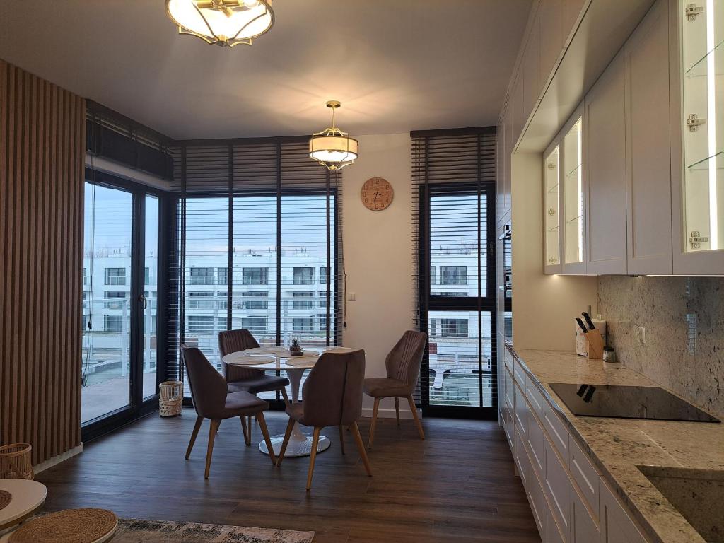 a kitchen and dining room with a table and chairs at Sol Marina Apartament Marina Blue in Wiślinka
