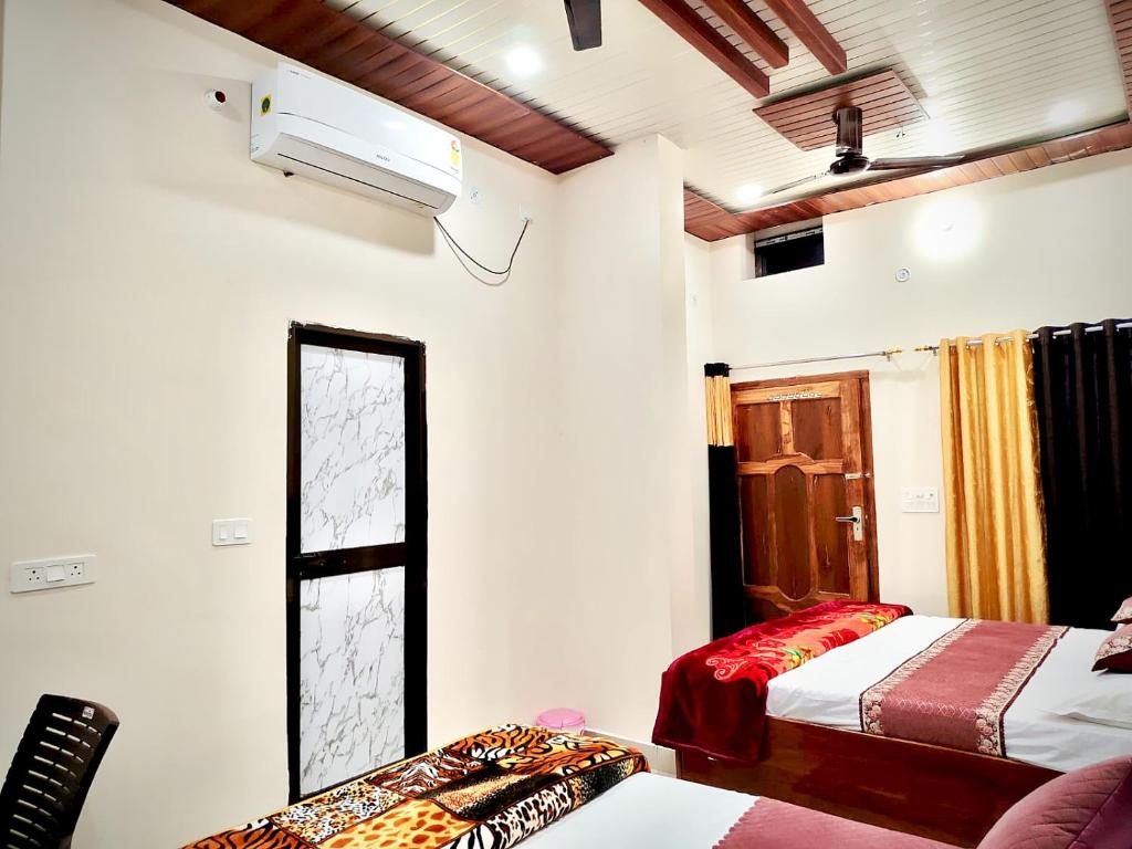 een kamer met 2 bedden en een raam erin bij Akshayavat Palace in Ayodhya