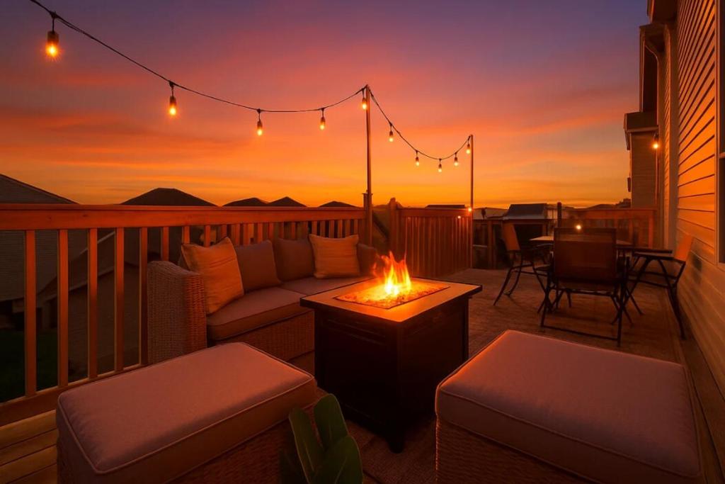a patio with a couch and a fire pit on a balcony at Chic 6BDRM Getaway - KingBed - Patio - BBQ - Garage - Wifi in Edmonton