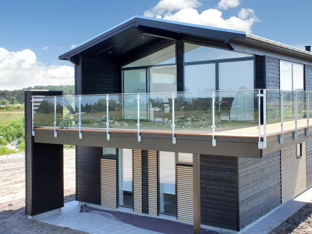 a house with a balcony on the side of it at Holiday Home Ugot - 750m from the sea by Interhome in Frederikshavn