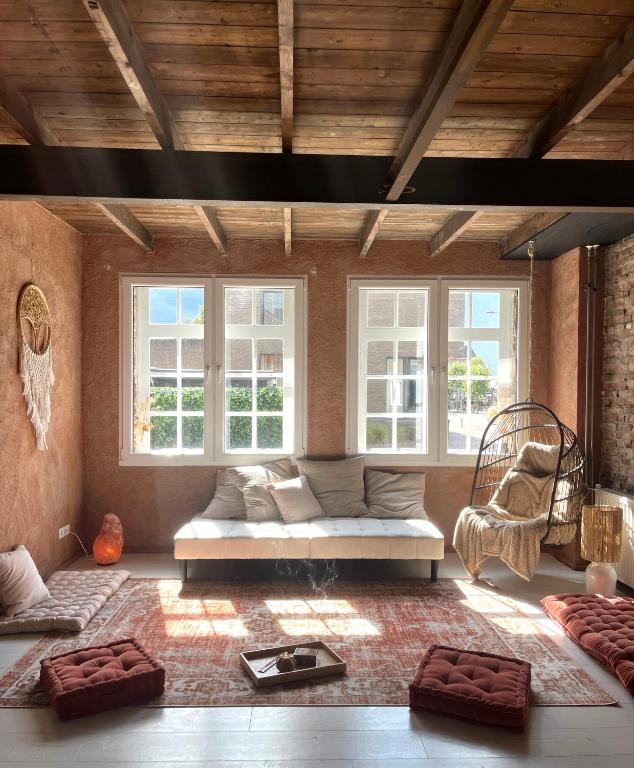 a living room with a couch and some windows at RetreatHouse in Lith