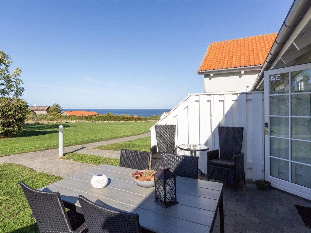 un patio con tavolo e sedie e l'oceano di Apartment Thamina - 400m from the sea by Interhome ad Allinge