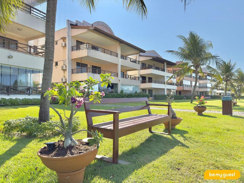 eine Parkbank vor einem Gebäude in der Unterkunft Condomínio Aquaville Resort in Mangabeira