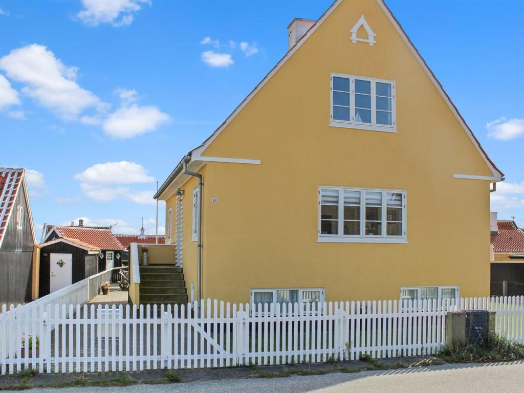 a yellow house with a white picket fence at Holiday Home Borka - 150m from the sea by Interhome in Skagen
