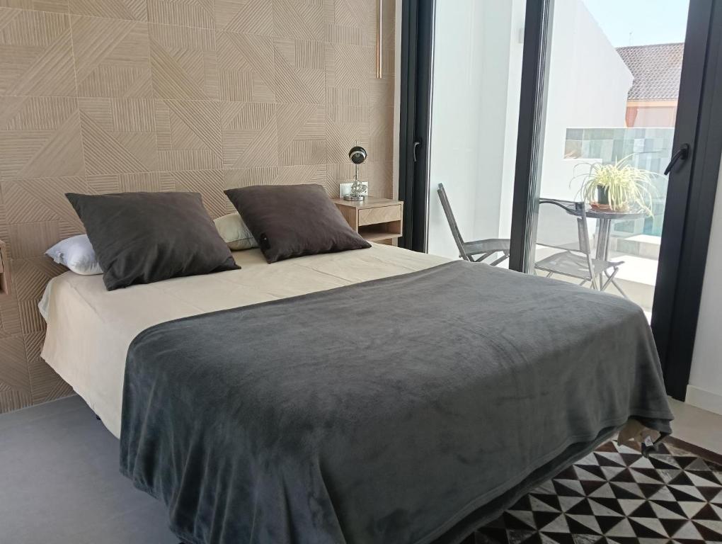 ein Schlafzimmer mit großem Bett und Balkon in der Unterkunft WOWHOLIDAYS Exclusive Building Center Ronda in Ronda